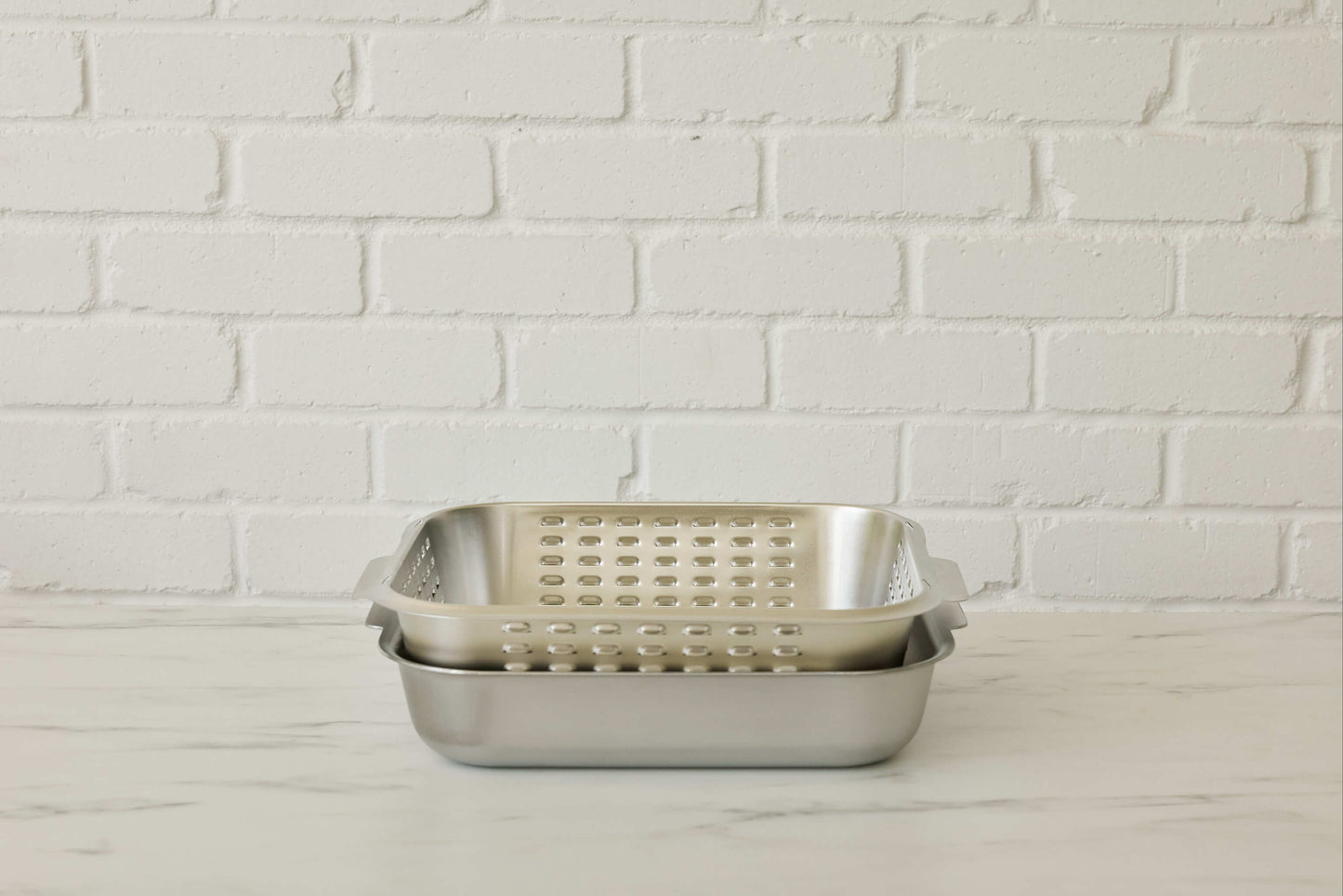 Stainless steel roasting pan with unique stainless steel vented spatter guard lid. Lid inverts neatly into base of the roasting pan for easy storage. Cookware made for real kitchens by a home cook.