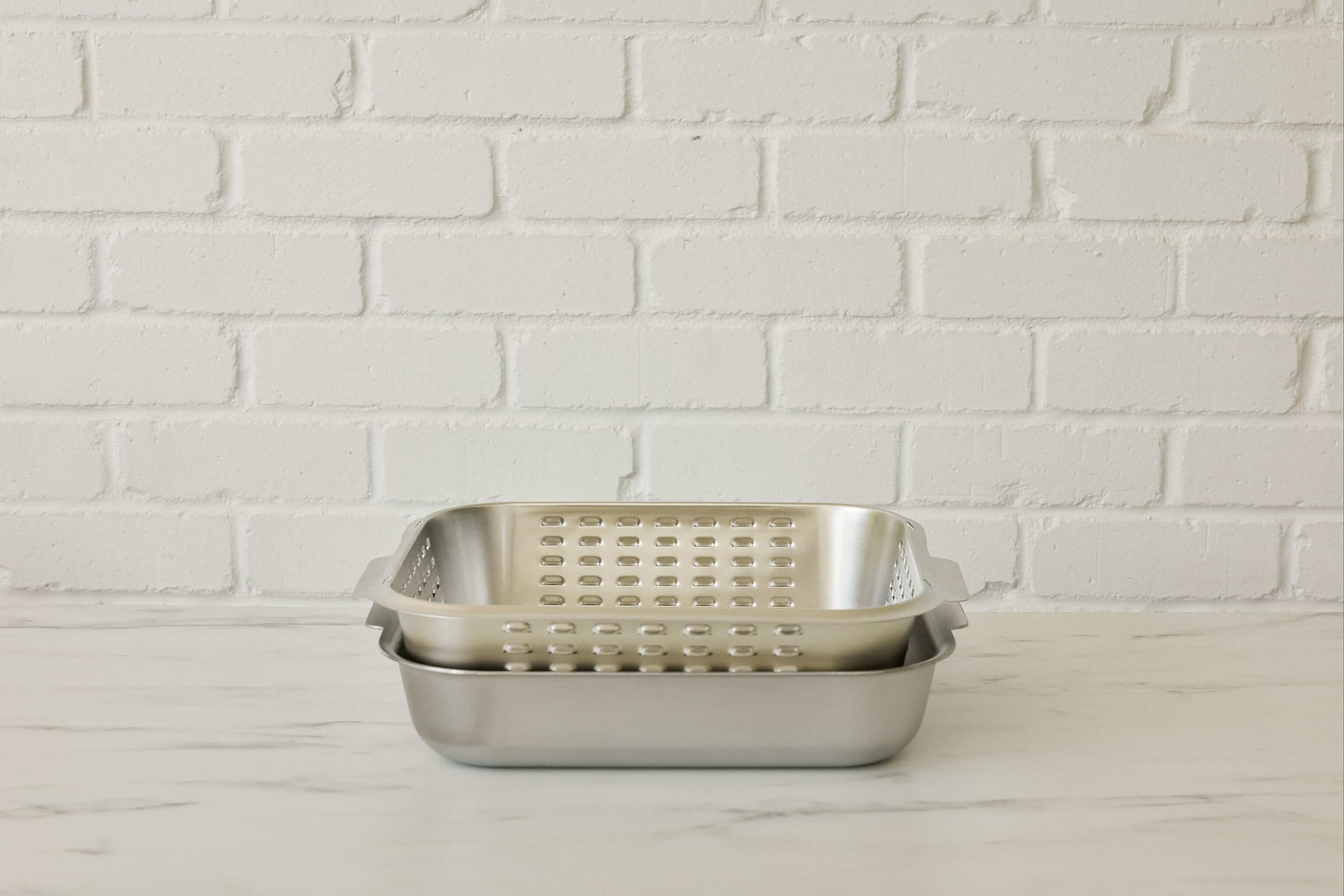 Stainless steel roasting pan with unique stainless steel vented spatter guard lid. Lid inverts neatly into base of the roasting pan for easy storage. Cookware made for real kitchens by a home cook.