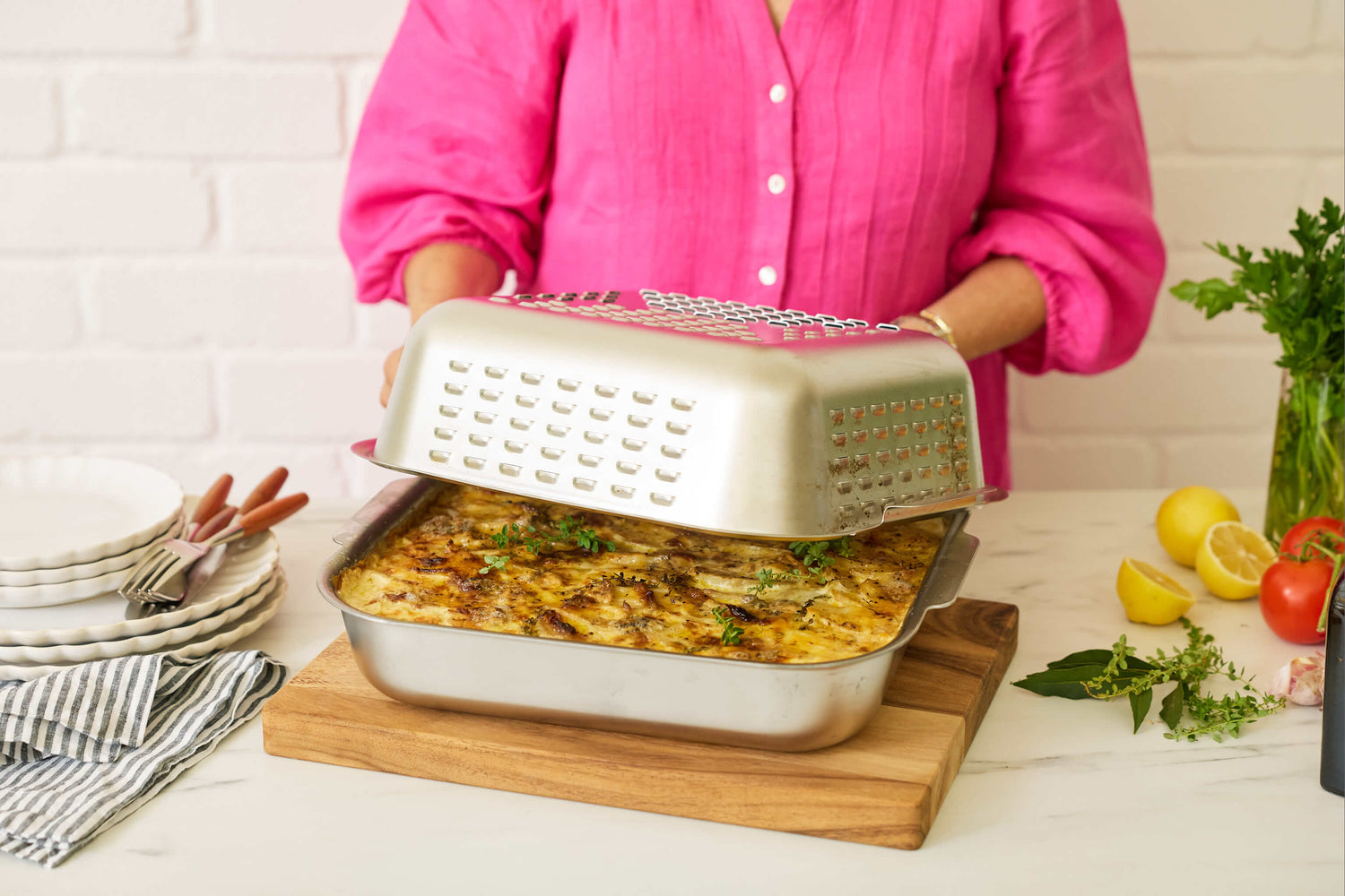 Louise with her invention, a no-mess roasting pan. The Hagane Home Ultimate Roaster comes with a vented spatter guard cover to keep the oven clean and cook a golden, juicy roast. 
