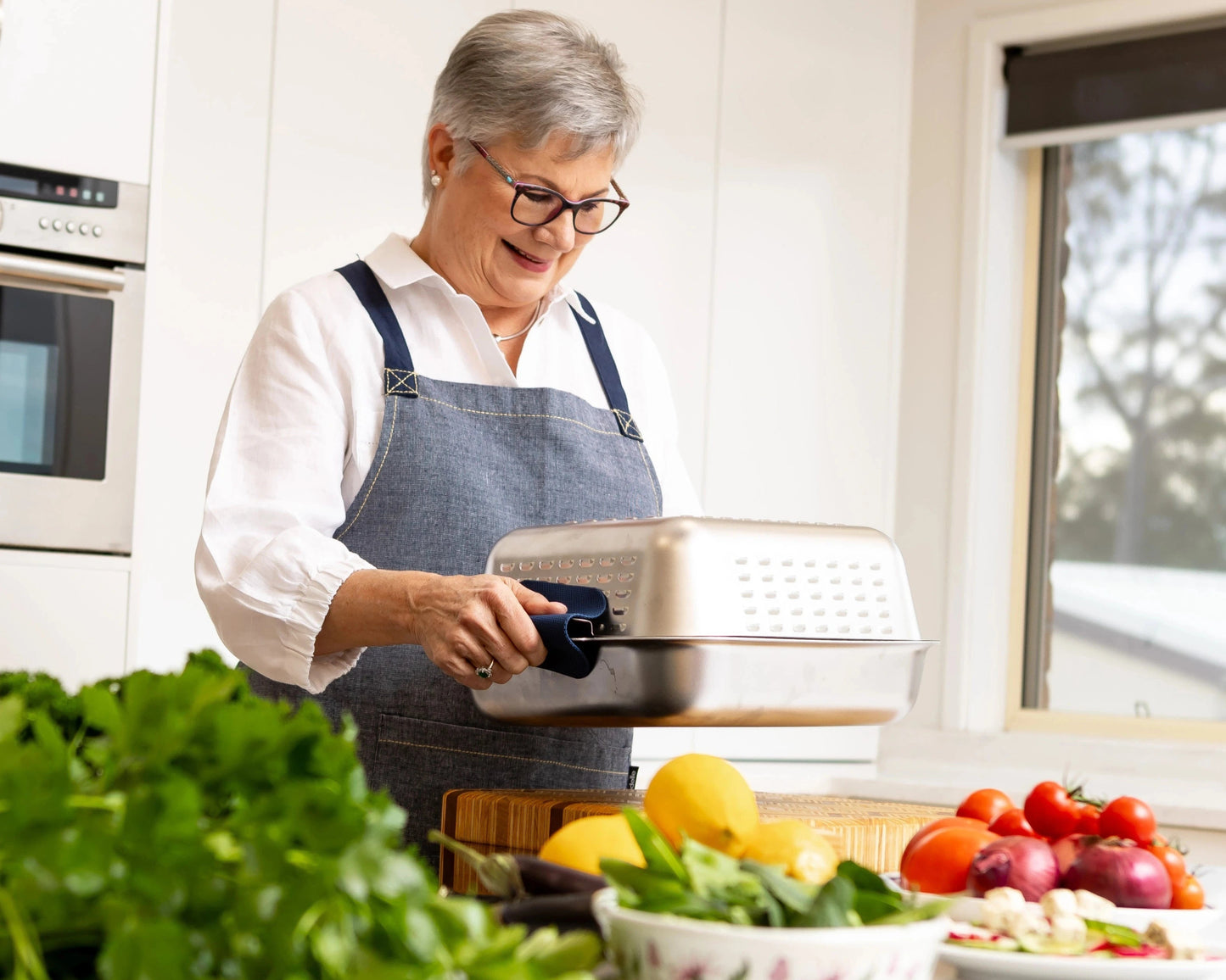 Founder Louise holding her invention: the Hagane Home Ultimate Roaster. A no-mess roasting pan designed for effortless roast nights. All the joy of roasting. None of the mess.