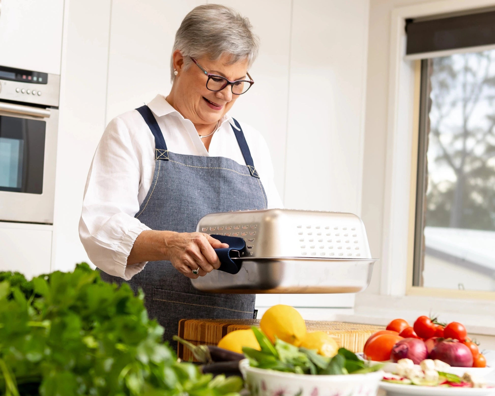 Founder Louise holding her invention: the Hagane Home Ultimate Roaster. A no-mess roasting pan designed for effortless roast nights. All the joy of roasting. None of the mess.
